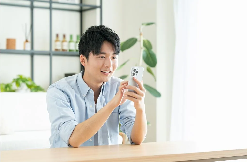 男性がスマホ操作をする写真