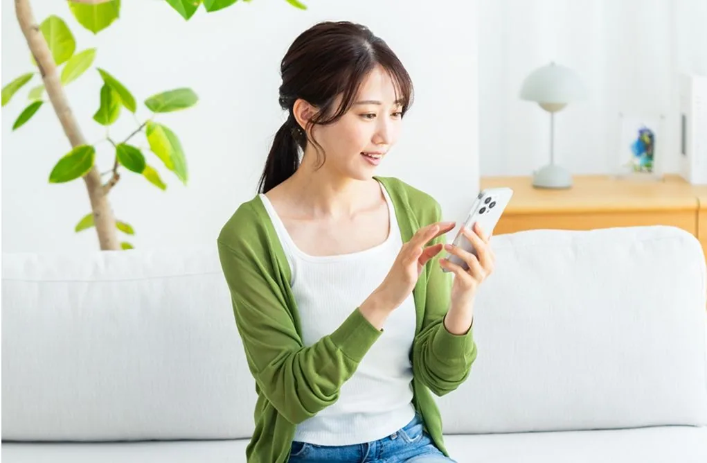 女性がスマホ操作をする写真